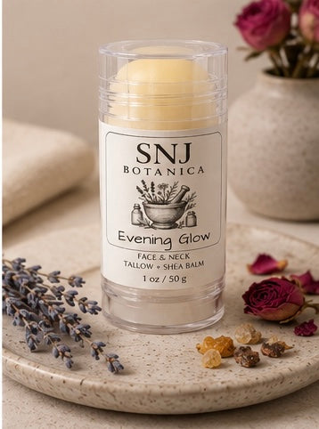 Balm stick with 'SNJ Botanica' label on a stone surface with flowers and lavender.