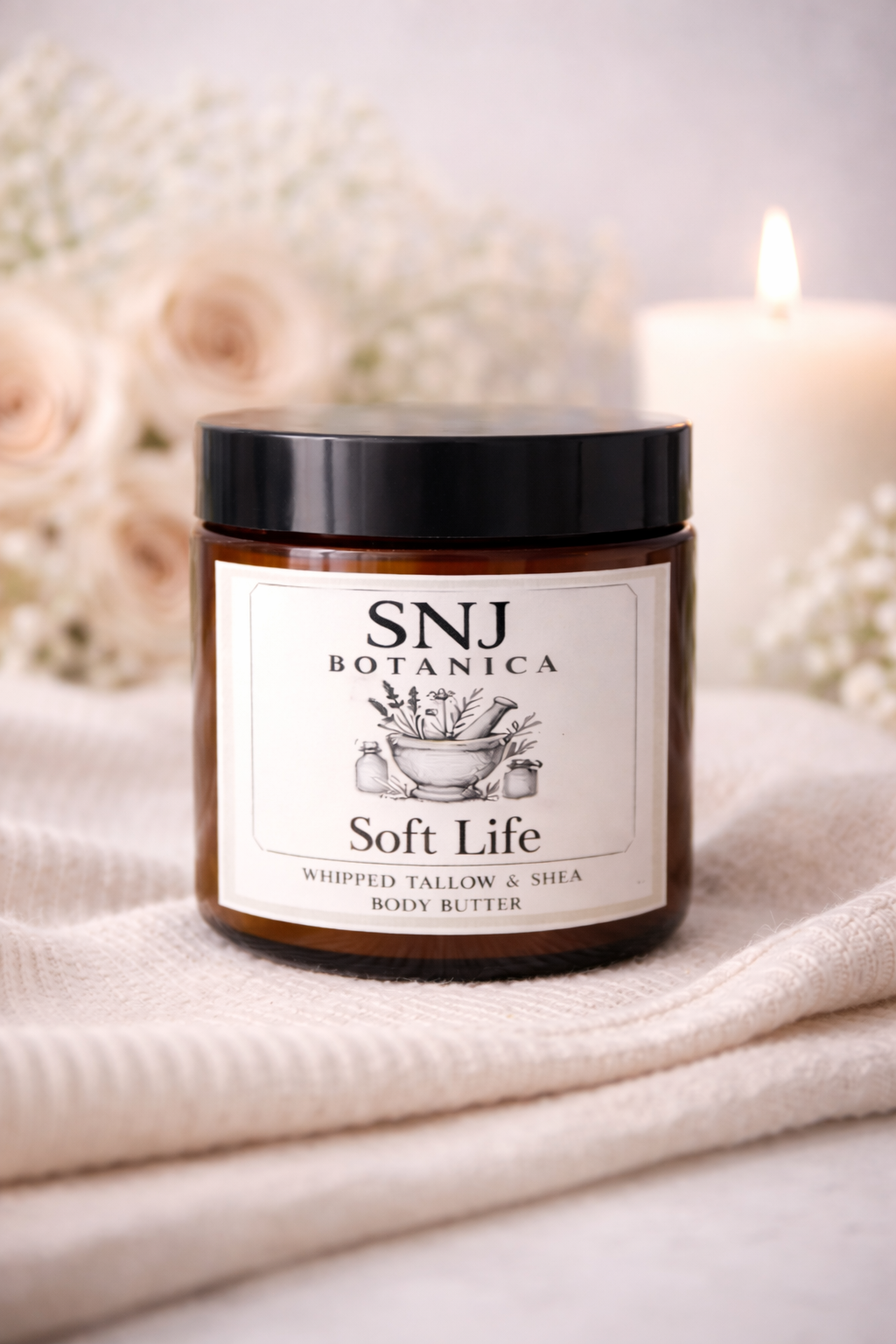 Jar of SNJ Botanica Soft Life body butter on a soft fabric background