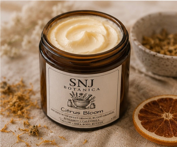 Jar of SNJ Botanica Citrus Bloom body butter with a label on a textured surface.