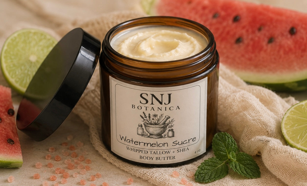 Jar of SNJ Botanica Watermelon Sucre body butter with watermelon slices and limes on a textured surface.