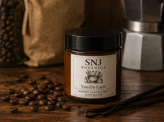 Jar of SNJ Botanica Vanilla Latte body butter with coffee beans and a vanilla pod on a wooden surface.
