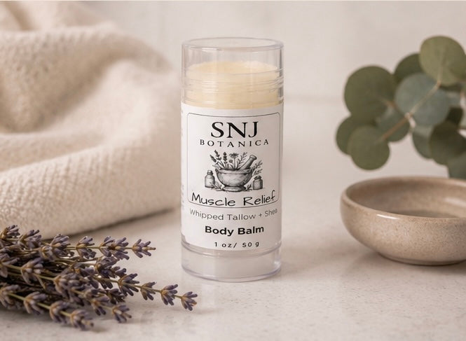 Body balm stick with 'SNJ Botanica' label on a neutral background with lavender and a bowl.