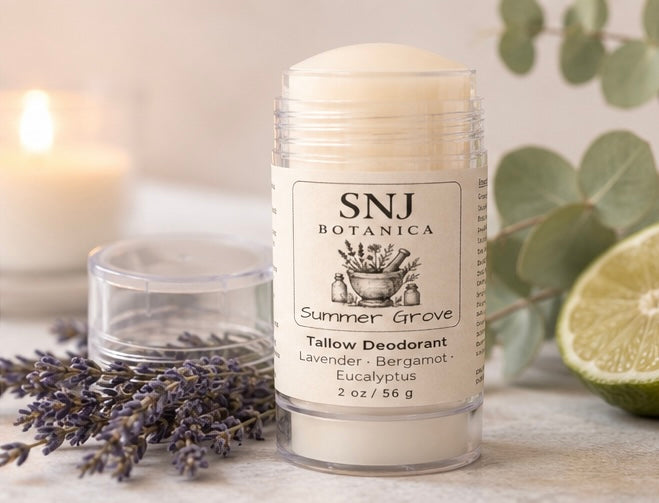 SNJ Botanica tallow deodorant stick with lavender, bergamot, and eucalyptus on a wooden surface with a candle and eucalyptus leaves in the background.
