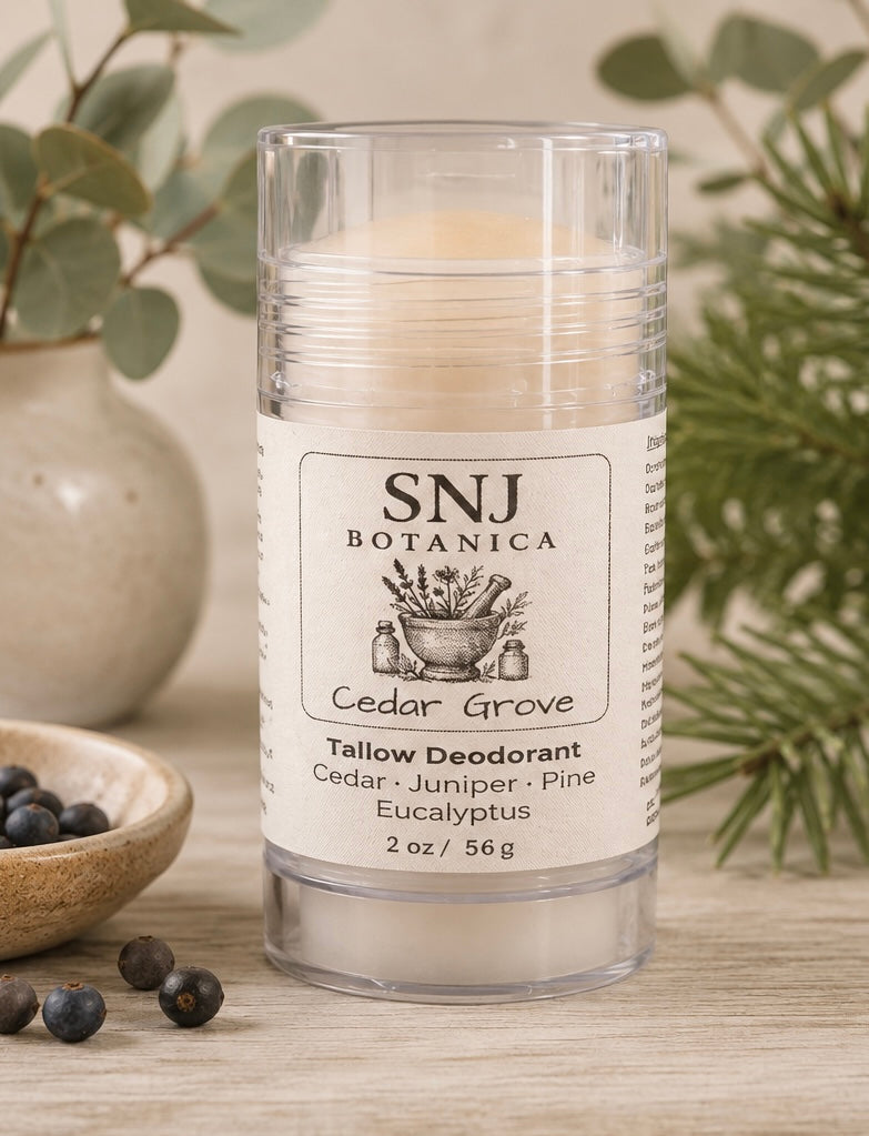 Candle with SNJ Botanica label on a wooden surface with greenery in the background