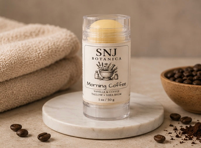 Balm container labeled 'SNJ Botanica Morning Coffee' on a marble surface with coffee beans and a towel.