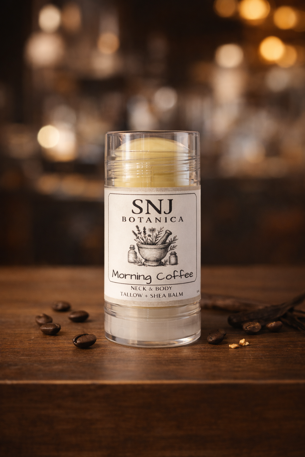 Bottle of SNJ Botanica Morning Coffee balm on a wooden surface with coffee beans.