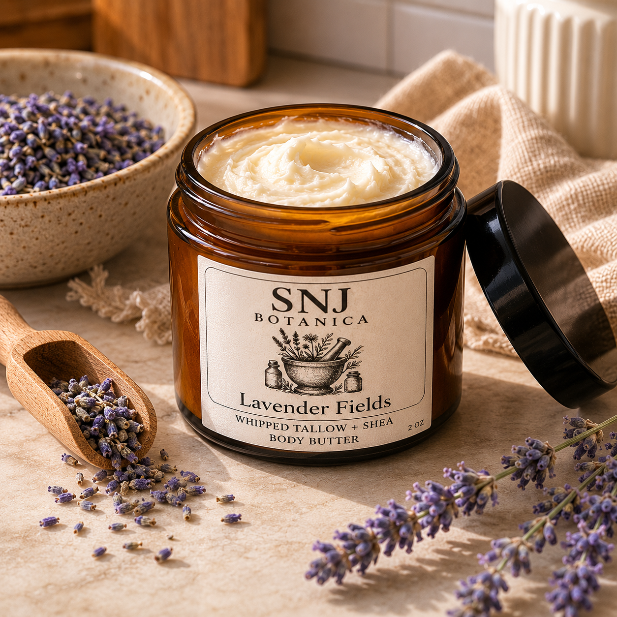 Jar of SNJ Botanica Lavender Fields body butter with lavender flowers and a wooden scoop on a textured surface.